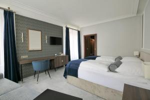 利托米什尔金星酒店的酒店客房设有一张大床和一张书桌。