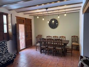 贝莱斯布兰科Casas Demi verhuurhuis的一间带桌椅和时钟的用餐室