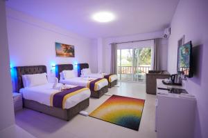 南威Canary Nungwi Hotel & Free SPA的酒店客房设有两张床和电视。