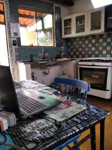 戈亚斯州上帕莱索hostel Lobeira的厨房里的笔记本电脑坐在桌子上