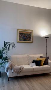 佛罗伦萨Appartamento Careggi con posto auto的客厅的白色沙发,墙上有绘画作品