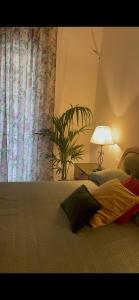 佛罗伦萨Appartamento Careggi con posto auto的一间卧室,配有带灯和植物的床