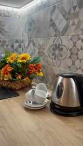 佛罗伦萨Appartamento Careggi con posto auto的厨房柜台配有烤面包机、杯子和鲜花