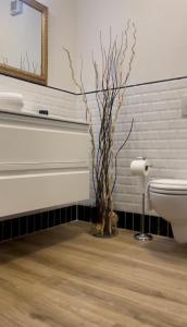 佛罗伦萨Appartamento Careggi con posto auto的一间带卫生间的浴室和一个带枝子的花瓶
