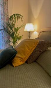 佛罗伦萨Appartamento Careggi con posto auto的床上的枕头,带灯和植物