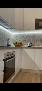 佛罗伦萨Appartamento Careggi con posto auto的厨房配有白色橱柜、水槽和炉灶。