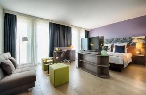 慕尼黑慕尼黑城市东部莱昂纳多酒店的酒店客房,配有床和电视