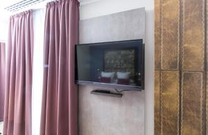 巴塞罗那巴塞罗那圣家堂莱昂纳多精品酒店的窗户旁墙上的平面电视