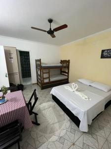 圣代佩德罗Pousada das Estrelas的一间卧室配有一张床、一张桌子和风扇