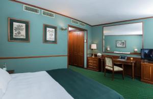 米兰米兰市中心莱昂纳多酒店的酒店客房带一张床、一张书桌和一面镜子