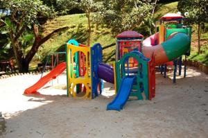 热河市Thermas Paradise Apart的公园里一个带五颜六色游戏设备的游乐场