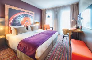 慕尼黑慕尼黑市南莱昂纳多酒店的酒店客房设有一张大床和一张书桌。