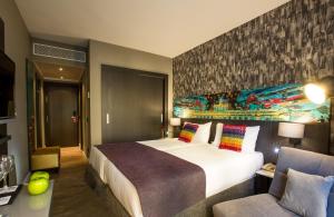 马德里马德里莱昂纳多精品酒店的酒店客房设有一张大床和一张沙发。