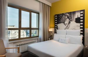 米兰NYX Hotel Milan by Leonardo Hotels的酒店客房设有床和窗户。