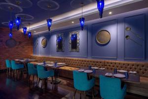 加济阿巴德Radisson Blu Kaushambi Delhi NCR的一间配备有桌子和蓝色椅子的用餐室