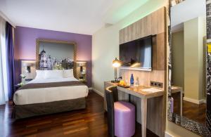 马德里马德里市中心莱昂纳多酒店的配有一张床和一张书桌的酒店客房