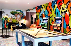 曼海姆NYX Hotel Mannheim by Leonardo Hotels的一间设有乒乓球桌和壁画的房间