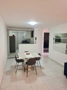 纳塔尔Solar Areia Preta 302的厨房以及带白色桌椅的用餐室。