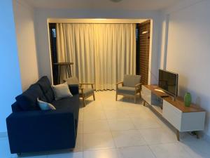 纳塔尔Solar Areia Preta 302的客厅配有蓝色的沙发和电视