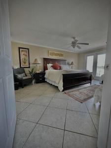 比洛克西Biloxi Beach Condo的一间大卧室,配有一张床和一架钢琴
