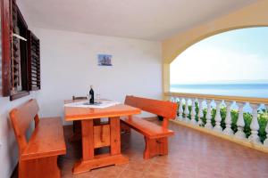 布拉托Apartments by the sea Prigradica, Korcula - 543的一间带桌子、长凳和窗户的用餐室