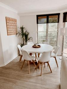 拜伦湾海风主海滩公寓的白色的用餐室配有白色的桌椅