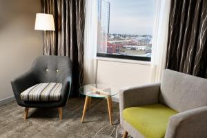 珀斯珀斯城市中心假日酒店的客厅配有椅子、桌子和窗户
