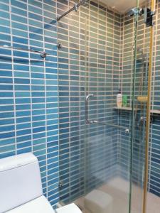 象岛Paradise的浴室设有淋浴、卫生间和蓝色瓷砖。
