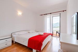 拉茨斯切Apartments by the sea Kneza, Korcula - 10168的一间白色卧室,床上铺有红色毯子