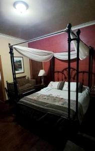 卢汉德库约Quinta Ugarte的一间卧室配有天蓬床和沙发