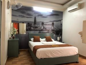 海防科济酒店的一间卧室,配有一张带城市绘画的床