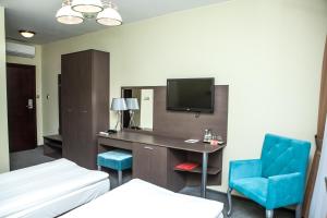 马佐夫舍地区新庄园莫德林机场索克沃弗斯卡酒店的酒店客房设有一张床、一张书桌和一台电视机。
