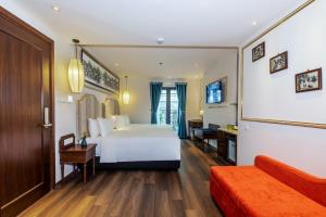 河内Hanoi Calista Hotel的一间酒店客房,配有一张白色的床和一张书桌