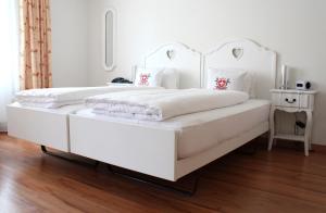 因特拉肯维赛斯克鲁兹酒店的白色卧室配有2张白色的床和桌子
