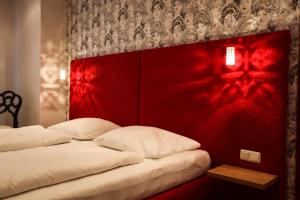 萨尔茨堡卡瑟勒布劳老城区酒店的红色墙壁的客房内的两张床