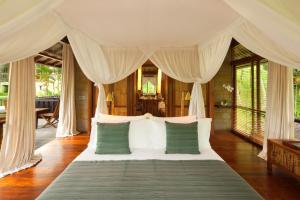 帕洋安COMO Shambhala Estate的一间卧室配有带绿色和白色枕头的床