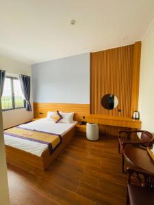 潘郎Khách sạn Sớm Phú Quý 2 - Phan Rang的一间卧室配有一张床、一张桌子和一台电视。