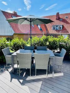 伊策霍Schöne Ferienwohnungen teilweise mit Dachterrasse im Herzen von Itzehoe的甲板上配有桌椅和遮阳伞