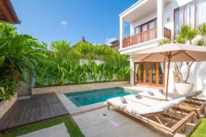 库塔Puspa Ayu Villas & Apartments的一座带游泳池和房子的别墅