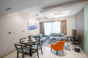迪拜City Premiere Hotel Apartments - Dubai的客厅配有桌子和沙发