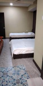 拿笃Tabin Lodge的配有两张单人床的客房,铺有地毯
