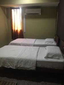 拿笃Tabin Lodge的卧室设有两张单人床和窗户。