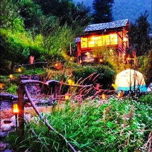 卡索尔Parvatis Lap Luxury Hostel & Camps的花园中夜晚的灯光房子