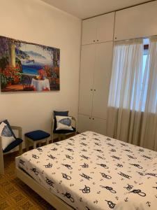 维耶特里Arco Apartment - Vietri sul Mare的卧室配有一张床,墙上挂有绘画作品