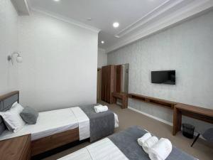 费尔干纳Emin hotel的酒店客房设有两张床和一台平面电视。