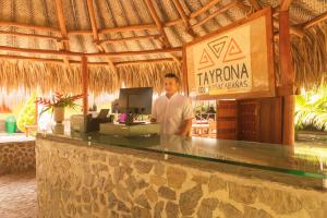 埃尔扎伊诺Camping Tequendama Playa Arrecifes Parque Tayrona的站在度假村酒吧后面的人