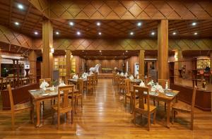 娘瑞KMA Inle Hotel的一间设有木桌和椅子的餐厅
