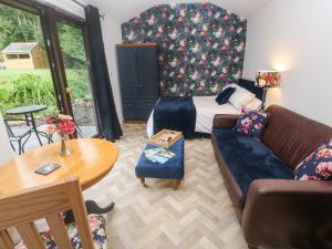 圣奥斯特尔Peony Cottage的客厅配有床和沙发