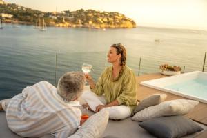 圣蓬萨Iberostar Selection Jardín del Sol Suites - Adults Only的坐在船上的女人和男人,喝一杯酒
