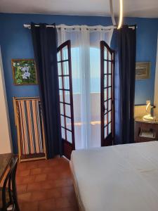 罗克布吕讷-卡普马丹Soutariba的一间拥有蓝色墙壁的卧室、一张床和窗户